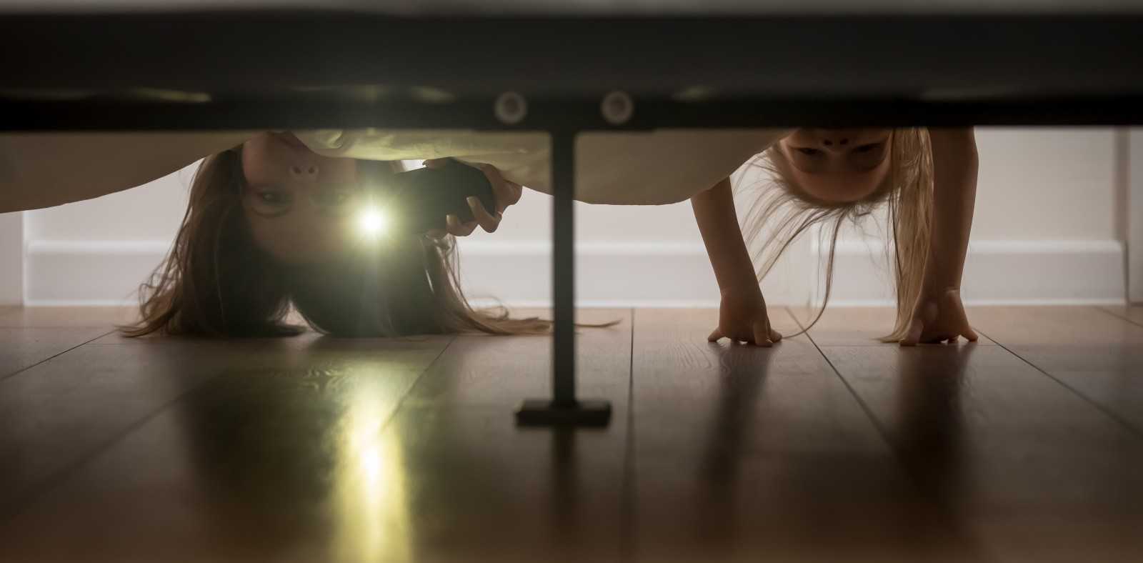 Девушка заглядывает под кровать